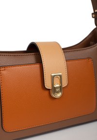 Borsa a tracolla in pelle marrone con una tasca frontale arancione texture e una tracolla color sabbia. Presenta una chiusura in tono oro e un design elegante e rettangolare.