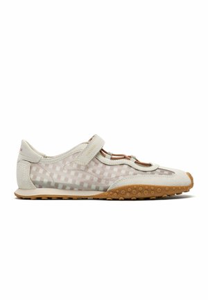 Baskets en mesh beige clair et suède avec bride Velcro, semelle marron texturée et détails découpés le long du côté supérieur.