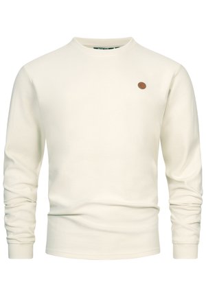 Maglione a coste color bianco sporco a maniche lunghe con scollo rotondo e una piccola toppa rotonda marrone con logo sul petto sinistro.
