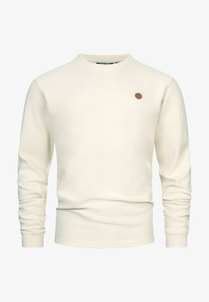 Maglione a coste color bianco sporco a maniche lunghe con scollo rotondo e una piccola toppa rotonda marrone con logo sul petto sinistro.