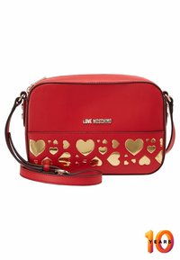 Borsa a tracolla rossa in materiale sintetico, con un design a cuore dorato ritagliato sul davanti e una tracolla rimovibile.