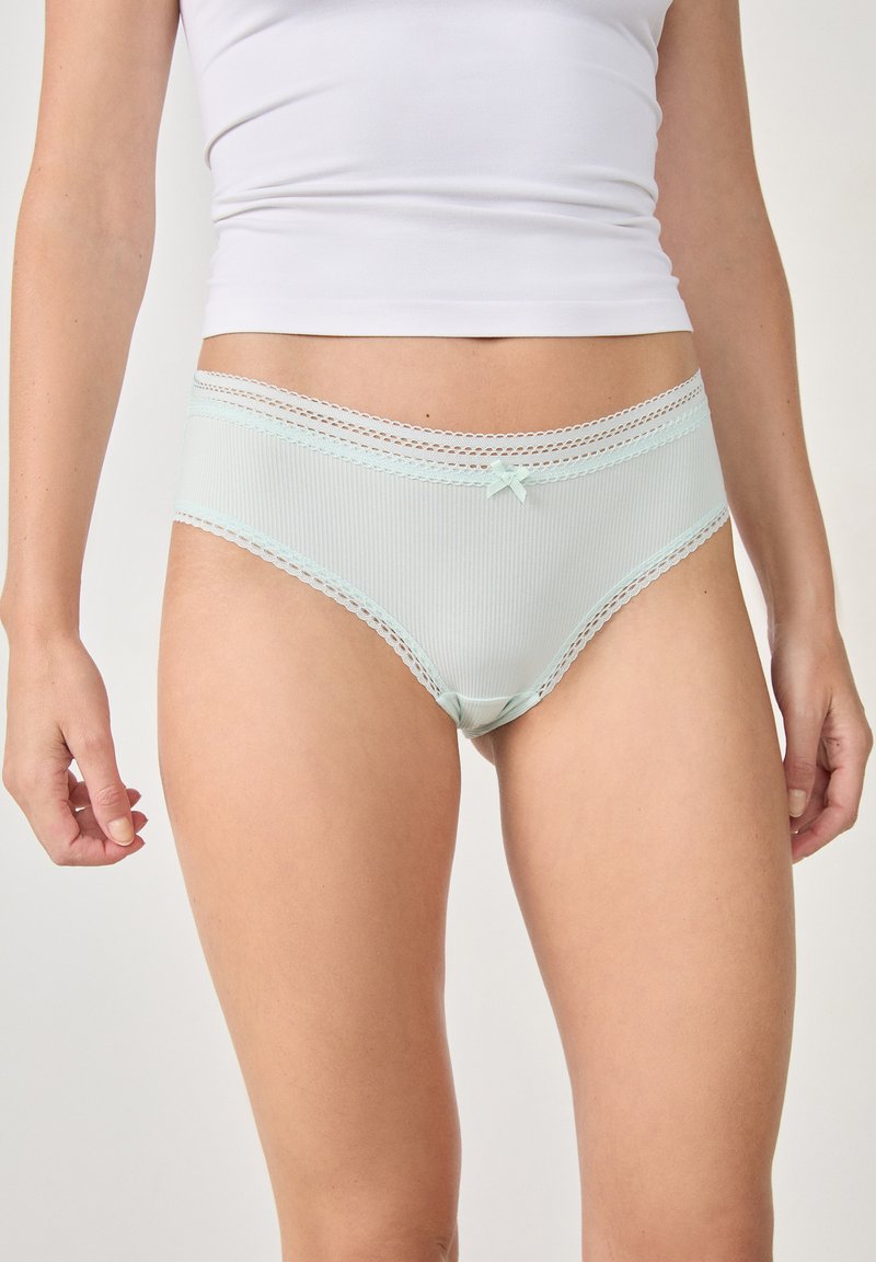 Mutande da donna verde menta chiaro in materiale a coste, con pizzo lungo l'elastico in vita e un piccolo fiocco decorativo sul davanti.