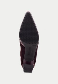 Burgundy semišová vysoká botička s špičatou špičkou a texturovanou černou gumovou podrážkou. Čtverec paty s hladkým povrchem a jemným brandingem.