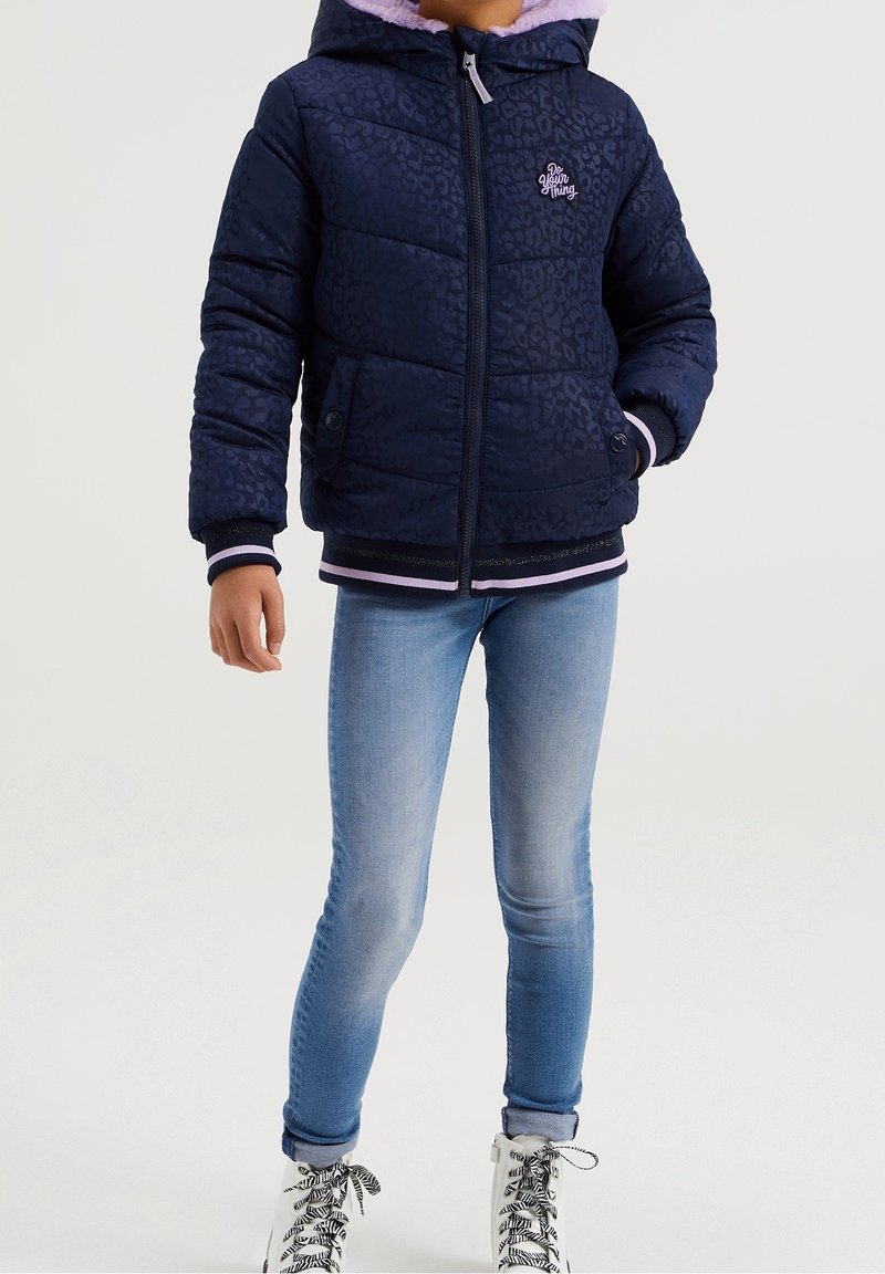 Marineblauwe pufferjack met leopardprint, paarse capuchonvoering, ritssluiting, ribgebreide manchetten en zoom met roze en zwarte accenten.