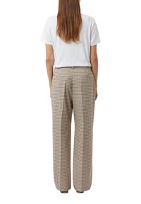 Pantaloni a quadri beige con vita alta, gambe ampie e due tasche posteriori. Realizzati in tessuto testurizzato, presentano una chiusura con bottone e passanti per cintura.