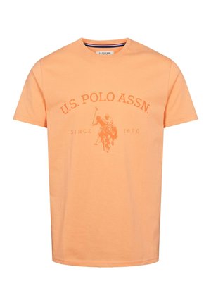 Pomarańczowa bawełniana koszulka z okrągłym dekoltem, z centralnym nadrukiem przedstawiającym gracza polo oraz napisem "U.S. POLO ASSN." poniżej. Krótkie rękawy, standardowy krój.