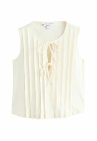 Blouse sans manches ivoire avec texture plissée, détail noué devant et encolure arrondie. Tissu doux offrant une sensation légère.