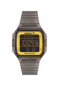 Montre numérique avec un bracelet transparent gris et un cadran rectangulaire jaune et noir. Ses caractéristiques incluent un boîtier résistant aux chocs et plusieurs boutons.