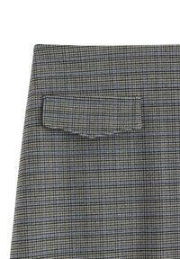 Gråternet stof med en lille patch lomme på bagsiden, med et tekstureret, vævet design og en subtil farvevariation.