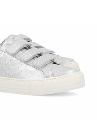 Silver metallic sneakers with three adjustable Velcro straps, perforated detailing on the sides, and a textured white rubber sole.