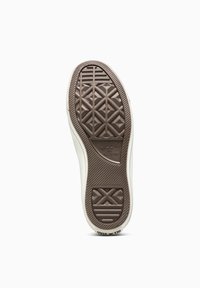 Suela de goma marrón de una zapatilla, con un patrón geométrico texturizado y el logo "Converse All Star". Los bordes son blancos con un acabado suave.