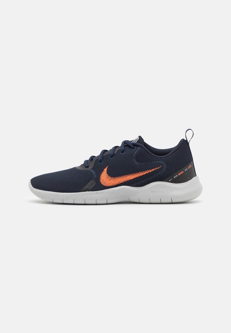 Chaussures de course Nike avec un dessus en maille bleu marine et un logo orange, dotées d'une semelle blanche flexible et de détails texturés sur les côtés.