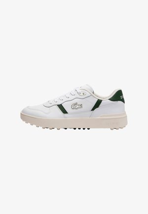 Baskets en cuir blanc avec des accents verts, lacets plats, col rembourré et semelle en caoutchouc texturée avec de petits picots pour la traction. Logo Lacoste présent.