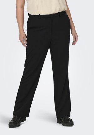 Black wide-leg trousers, tailored design, smooth fabric, featuring a waist pleat and discreet side pockets, paired with black platform shoes.