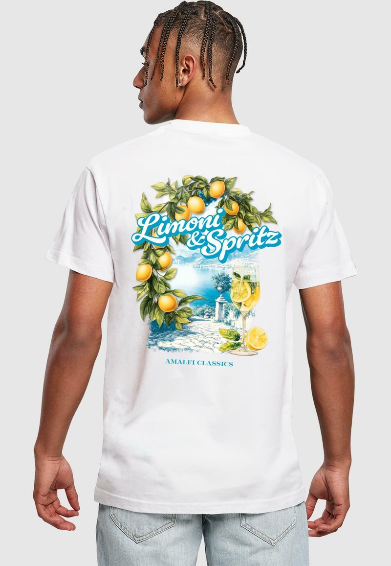 Camiseta de algodón blanca con un gráfico colorido de limones y una bebida, ambientada en una escena costera, con el texto "Limoni & Spritz."