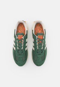 Zelené semišové a síťované tenisky Adidas se třemi bílými pruhy, oranžovými akcenty a texturovanou stélkou. Klasický design na šněrování.