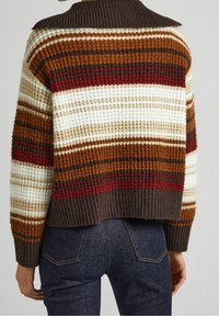 Sweter w paski z włóczki w brązowych, czerwonych, kremowych i złotych odcieniach, z prążkowanym dołem i szerokim kołnierzem. Tkanina ma fakturowaną, grubą strukturę.