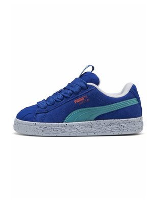 Zapatilla de ante azul con una raya turquesa, suela blanca gruesa moteada, cordones redondeados y logotipo rojo Puma Suede XL en el lateral exterior.