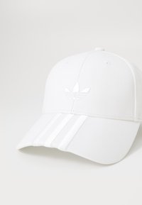 Witte pet met een textuurstof, gebogen rand, drie witte strepen aan de voorkant en een reliëflogo in het midden.