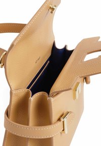 Borsa a mano in pelle beige con un design strutturato, dettagli in metallo dorato e un interno blu, dotata di una tasca con zip e scomparti aperti.