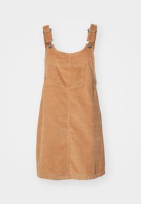 Latzkleid aus Cord in Hellbraun, mit verstellbaren Trägern und einer Rückentasche. Der Stoff hat eine gerippte Textur und ein lässiges Design.