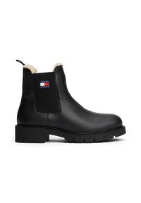 Bottines Chelsea en cuir noir avec une finition texturée, doublure douce, panneaux latéraux élastiques et une étiquette logo. Semelle épaisse et crantée pour une meilleure traction.