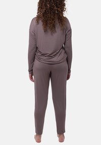 Mjuk, långärmad gråbeige lounge-set i lätt tyg, med draperad ryggdetalj och smalnande byxor.