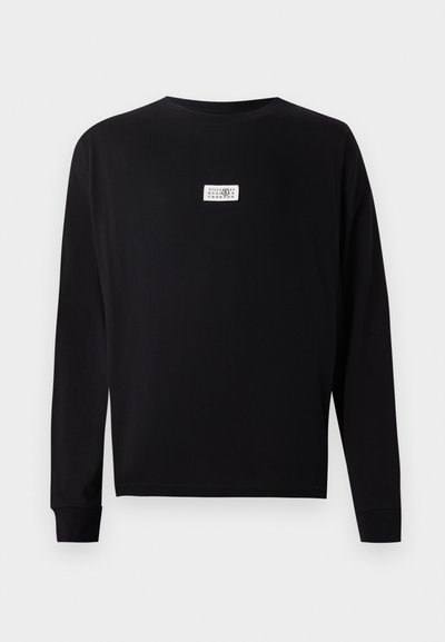 Black long-sleeve t-shirt made of cotton with a crew neck. Features a small white label in the center. Smooth texture and a relaxed fit.