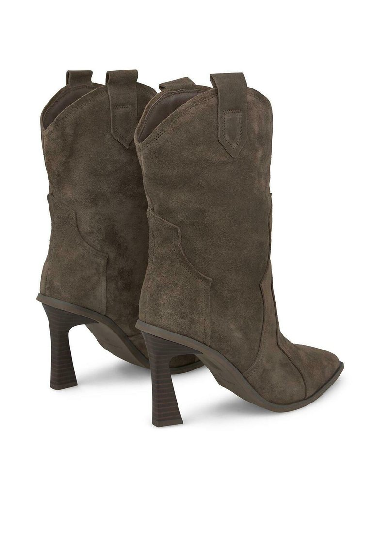 Botas de vaquero de ante marrón con punta afilada, altura hasta el tobillo y tacón apilado. Presentan un diseño occidental con tiradores laterales para ponerse fácilmente.
