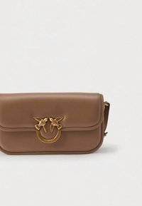 Καφέ δερμάτινη τσάντα ώμου με χρυσή κυκλική λεπτομέρεια κι έκλειμμα με σχέδια δύο πουλιών. Λείο υφή, δομημένο σχήμα.