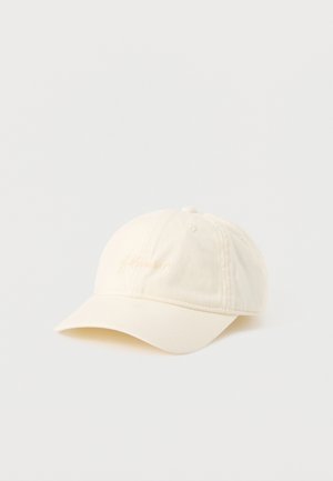 Casquette de baseball en coton blanc cassé avec une visière courbée et un texte brodé subtil à l'avant, présentée sur un fond blanc uni.
