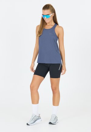 Blau- und grau gestreiftes sportliches Tanktop, schwarze Kompressionsshorts und graue Laufschuhe mit weißen Socken, die ein sportliches Design aufweisen.