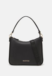 Borsa a mano in pelle nera con finitura texturizzata, accessori in oro, chiusura con zip e tracolla removibile con il nome del marchio in lettering in rilievo.