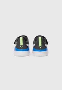 Chaussures de sport noires, blanches et bleues avec des onglets de traction vert fluo et logo Puma, vues de l'arrière sur un fond neutre.