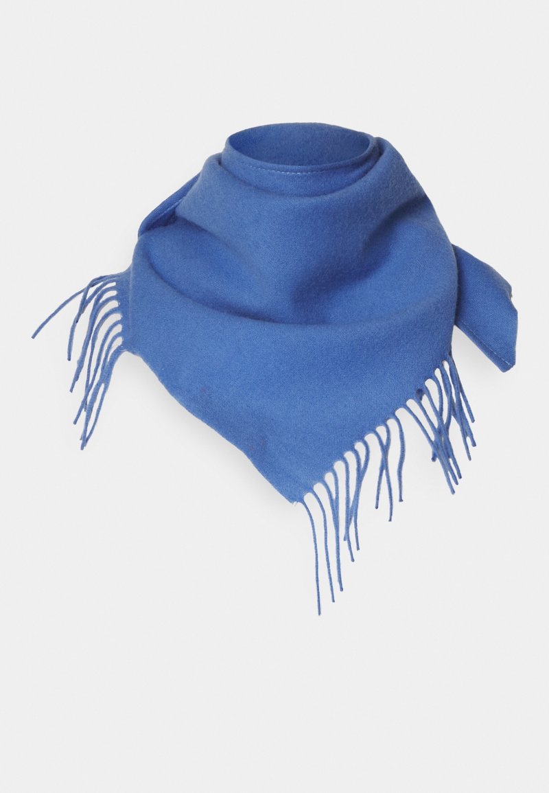 Écharpe en laine bleue avec bords frangés, enroulée en forme triangulaire lâche sur un fond clair.