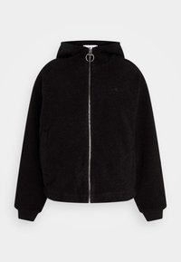 Czarna kurtka z polaru z kapturem, z zamkiem błyskawicznym z przodu i ściągaczami na mankietach. Na piersi wytłoczone logo Fila. Miękka w dotyku, o luźnym kroju.