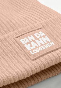Knit beanie in soft pink with a wide ribbed texture and a square fabric patch displaying white text: "BiN DA KANN LOSGEHEN."