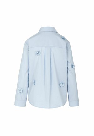 Gaiši zila garroku krekls ar apkakli, ar fakturētām ziedu izšuvumiem uz muguras un centrālu kroku detaļu.