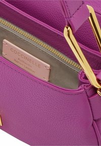 Borsa a tracolla in pelle viola con finitura testurizzata, hardware oro e interni grigio chiaro. Presenta un'etichetta del marchio all'interno.