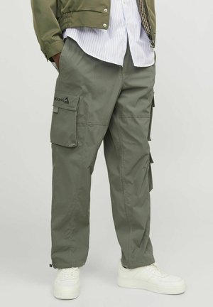 Pantalons cargo beige avec plusieurs poches latérales, fabriqués dans un matériau léger, présentant une coupe décontractée et un design fuselé avec des poignets à cordon de serrage.