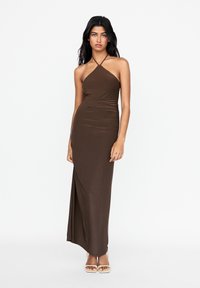 Braunes, halter-neck, ärmelloses Maxikleid mit einer figurbetonten Silhouette und gerafftem Textur. Glatter Stoff mit einem seitlichen Schlitz.