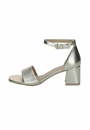 Sandale à talon argent métallique avec une bride à la cheville, bout ouvert et empeigne large. Dotée d'un talon bloc et d'une finition lisse.