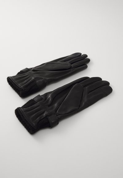 Must mustrõngad nahkkindad sileda tekstuuriga, elastsete soonte ja pehme voodriga. Kujundatud viie sõrmega ning minimalistliku esteetikaga.