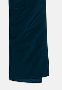 Tmavě modré měkké kalhoty z jemné látky s hladkým povrchem, vybavené elastickým manžetovým lemem a boční kapsou. Jednoduchý a funkční design.