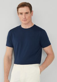 Námorně modré tričko s krátkým rukávem vyrobené z měkké tkaniny, s kulatým výstřihem a minimalistickým designem s malým logem na hrudi.