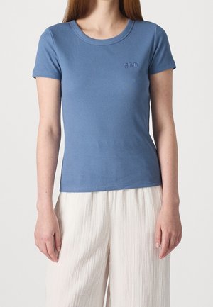 Sininen ribbineulottu T-paita, jossa on lyhyet hihat ja ylävasemmassa kulmassa hienovaraisesti kirjailtu GAP-logo. Kangas on sileäpintainen.