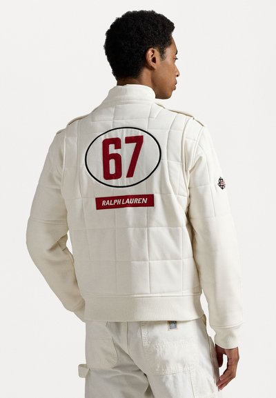 White quilted jacket with red number "67" and "Ralph Lauren" logo on back. Features collar, ribbed cuffs, and side pockets.