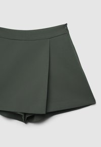 Pantaloni corti verdi a pieghe con una texture liscia e chiusura con zip sul retro, progettati con una vestibilità comoda e una forma svasata.