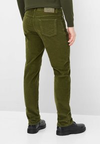 Olivengroene corduroy broek met een slanke pasvorm, gestructureerde stof, vijf zakken en een leren patch op de achterkant van de tailleband. Geschikt voor casual gebruik.