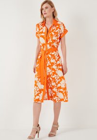 Orangenes Blumenkleid mit kurzen Ärmeln, durchgehender Knopfleiste und passendem Gürtel. Hergestellt aus leichtem Stoff mit fließendem Design.